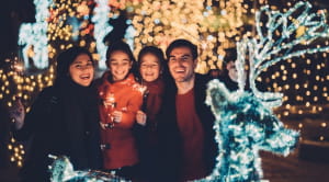 Family of four enjoying Christmas lights